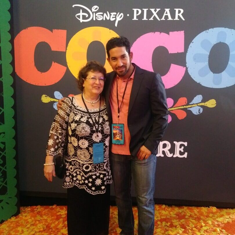 A man and woman posing for the camera at coco premiere