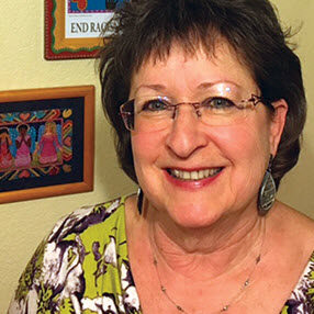 A woman with glasses smiling for the camera.